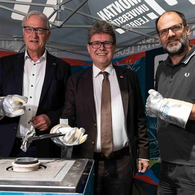 Bundesminister Martin Polaschek, Rektor Peter Moser von der Montanuniversität Leoben und Harry Jenner, Geschäftsführer des FM4-FreQuency-Festivals testen das neu entwickelte Verfahren zum Recycling von Aluminiumdosen Vorort. © MUL/Harald Tauderer