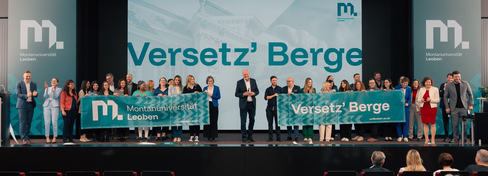 Group photo with the Technical University of Leoben employees on stage with the motto ‘Move mountains’.