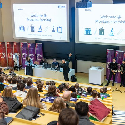 Vortragende und Hörer in einem Hörsaal an einer technischen Universität.